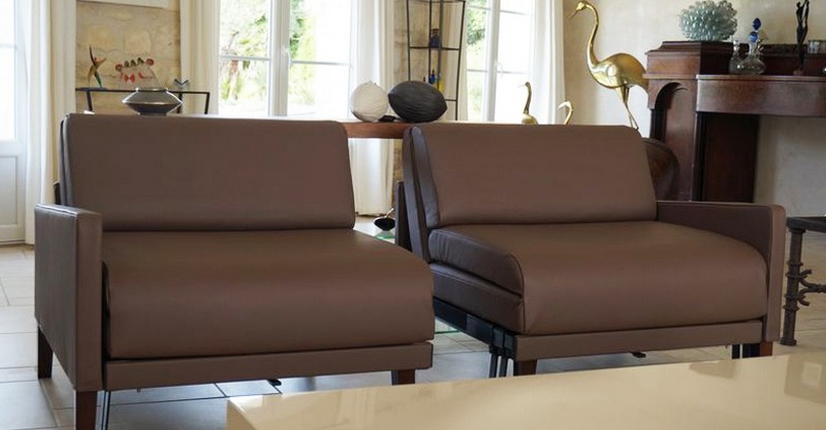 fauteuils lits en cuir marron Likoolis dans un salon
